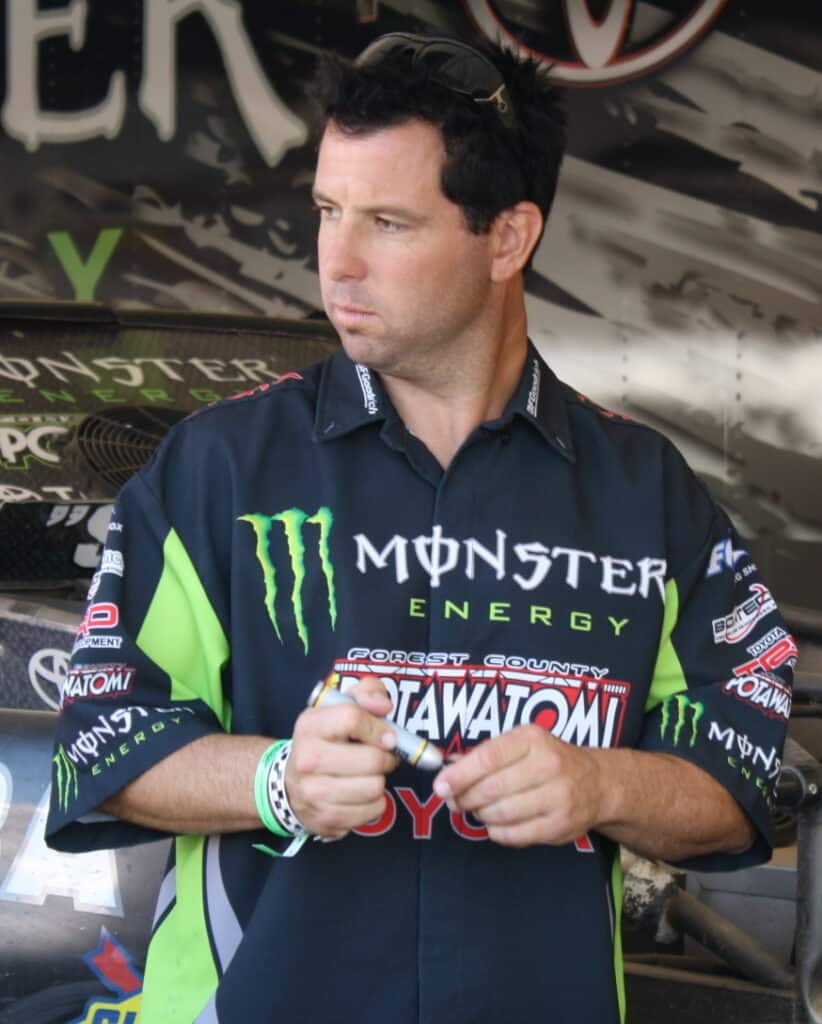 jeremy mcgrath holding a market with monster energy shirt on