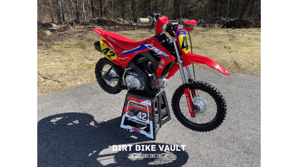 CRF 110 on a dirt bike stand on pavement